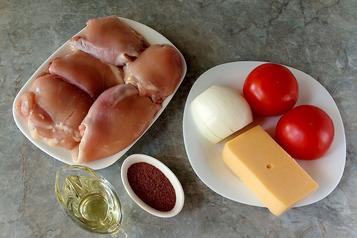 Смачні курячі стегна з овочами і сиром, запечені в духовці
